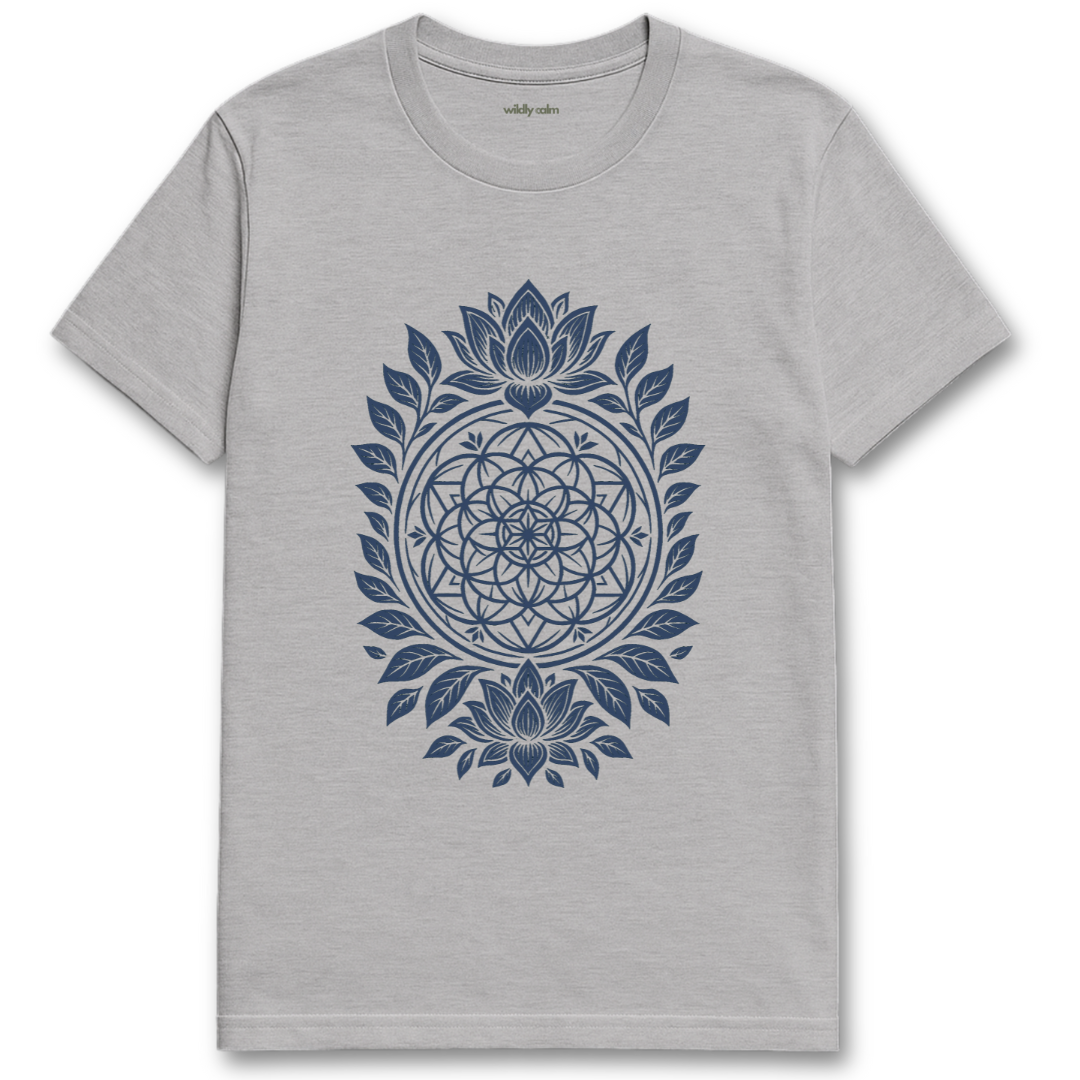 Wildly Calm_Floral Whorl Mandala sports grey yogat-shirt with blue geometric design on a white background