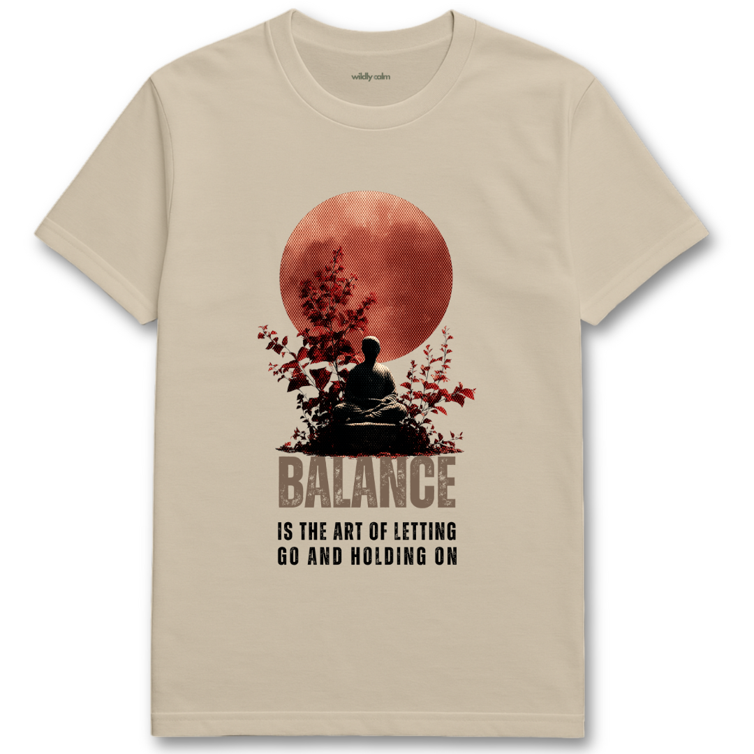 Life Balance Quote_Sand yoga t-shirt with a graphic of a person meditating under a red moon and the text 'Balance is the art of letting go and holding on'. - wildly calm