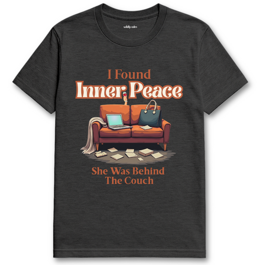 Heather Dark Grey t-shirt with a graphic of a couch and text 'I Found Inner Peace She Was Behind The Couch' on a white background - Wildly Calm