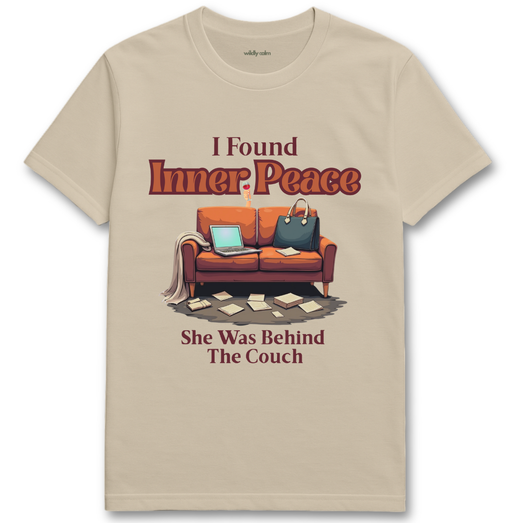 Sand/ Beige t-shirt with a graphic of a couch and text 'I Found Inner Peace She Was Behind The Couch' on a white background - Wildly Calm