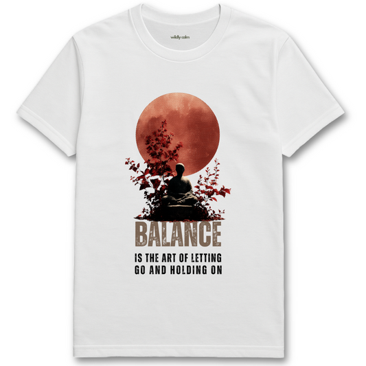 Life Balance Quote_white yoga t-shirt with a graphic of a person meditating under a red moon and the text 'Balance is the art of letting go and holding on'. - wildly calm